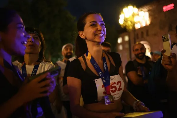 Jebid smiling among other runners after a night race in Yerevan, medal around her neck