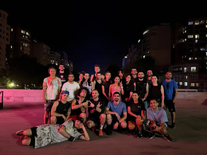 The group on the lit steps of a city square at night