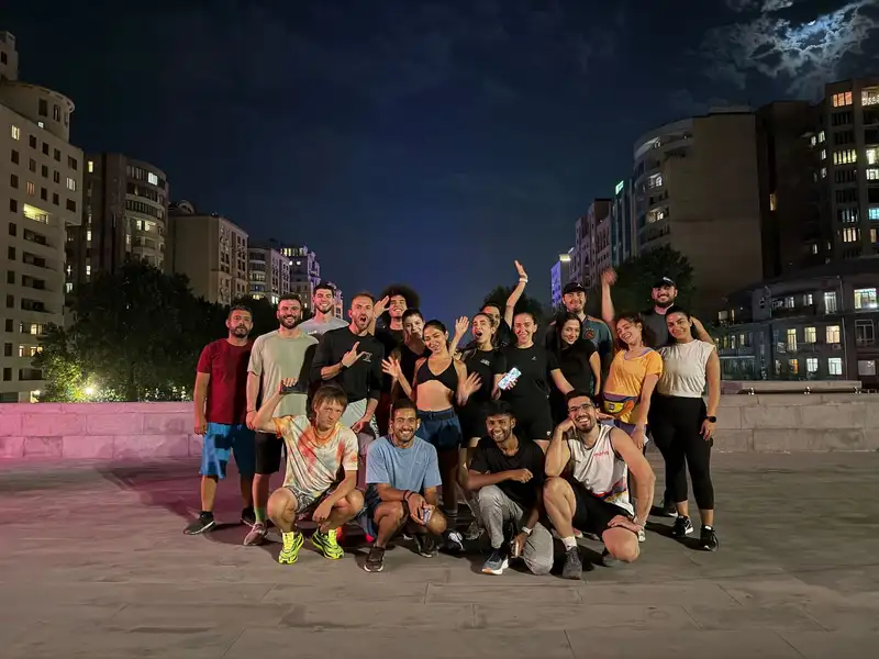 A group photo at night with the Yerevan skyline behind