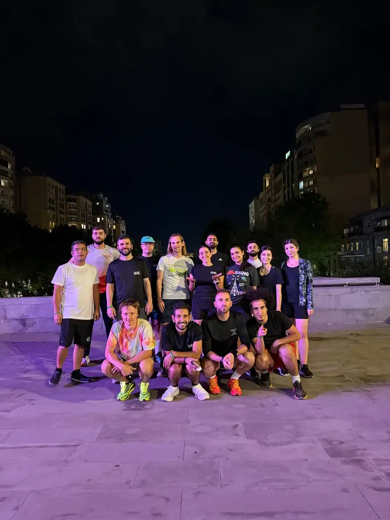 Runners on a purple-lit plaza after a night run