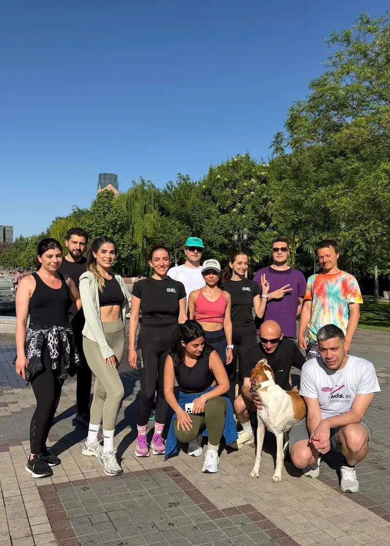The club on a tree-lined park path after a run, with a dog