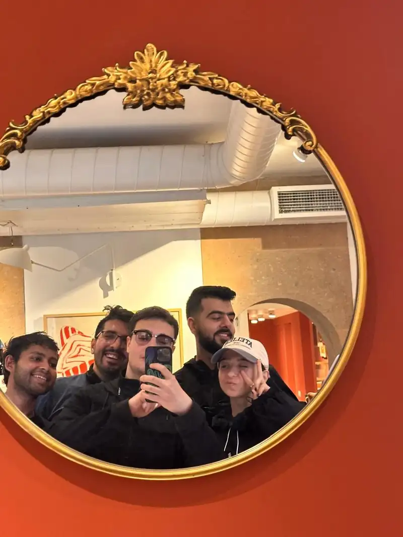 A group photographed in a round gilded mirror